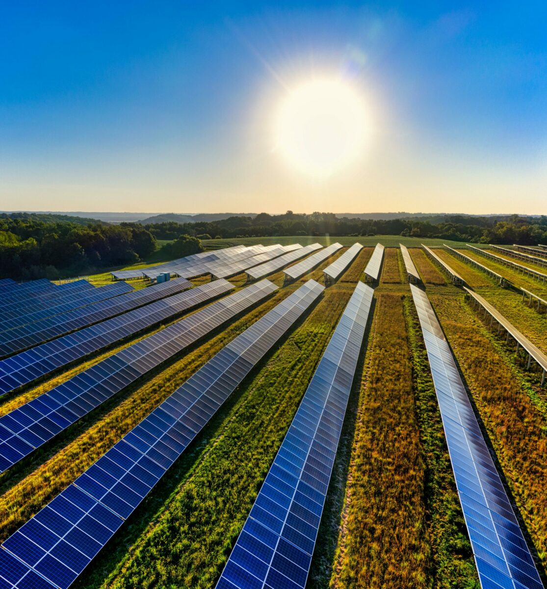 Sleek modern solar panels under a vibrant blue sky with clouds, symbolizing clean energy.